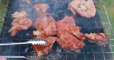 festa di maiale crudo marinato carne in salamoia con aceto con spezie cotte su spiedini su griglia barbecue all'aperto a legna per picnic estivo nella cucina esterna del ristorante per cena video