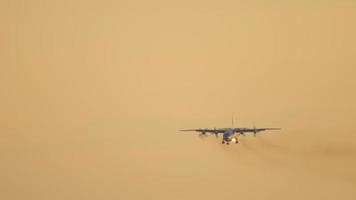 cargueiro aéreo turboélice militar se aproximando do aeroporto no fundo do céu pôr do sol. novosibirsk video
