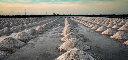 Salt farm in the morning with sunrise sky. Organic sea salt. Evaporation and crystallization of sea water. Raw material of salt industrial. Sodium Chloride. Solar evaporation system. Iodine salt. photo