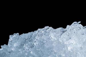 Pile of crushed ice cubes on dark background with copy space. Crushed ice cubes foreground for beverages, beer, whisky, fruit juice, milk, fresh food or fresh vegetables. photo