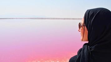 Caucasian woman tourist stand on Maharlu pink salt lake shore. Travel destination Iran in Shiraz
