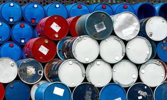 Stack of old chemical barrels. Blue, black and red oil drum. Steel and plastic oil tank. Toxic waste warehouse. Hazard chemical barrel. Industrial waste in drum. Hazard waste storage in factory. photo
