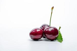 Red cherry with stalk and leaf isolated on white background. Ripe red sweet cherry. Sweet and juicy organic cherry. Fresh fruit for summer dessert. Raw material for jam industry. Antioxidant food. photo