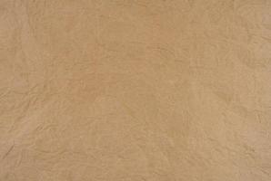 Old wrinkled brown paper texture background. Rough brown kraft paper texture. Recycle cardboard sheet. Rustic background pattern design. Closeup crumpled paper bag. Grunge and creased parchment. photo