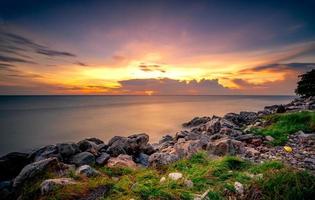 Rocks on stone beach at sunset. Beautiful beach sunset sky. Twilight sea and sky. Tropical sea at dusk. Dramatic sky and clouds. Calm and relax life. Nature landscape. Tranquil and peaceful concept. photo