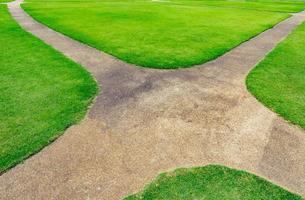 Pathway on the green lawn texture background. Intersection walkway photo