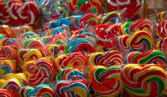 Colorful swirl lollipops at confectionery. Sweet candy for kids party. Candy day concept. Spiral rainbow color lollipops. Unhealthy food. Retro candy for kids. Handmade swirl lollypop. Junk food. photo