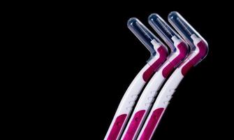 Three interdental brush with cover isolated on black background with copy space for text. Dental care concept. Equipment for get rid of food stuck in teeth photo