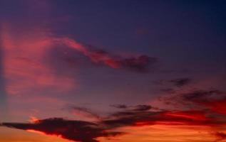 espectacular cielo rojo y azul oscuro y fondo de textura de nubes. nubes rojas, moradas y naranjas en el cielo del atardecer. el cielo al anochecer. fondo abstracto al atardecer. anochecer y amanecer. color de la naturaleza. concepto de libertad. foto