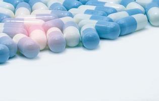 Blue-white pastel color capsule pills on white background. Global healthcare. Pharmaceutical industry. Pharmacy background. Antibiotic drug resistance. Pale blue medicine for toxic drug concept. photo