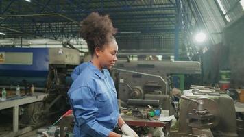 una joven ingeniera profesional de la industria trabaja con un uniforme de seguridad con herramientas de precisión de metalistería, tornos mecánicos y taller de piezas de repuesto en la fábrica de acero. video