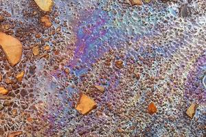 Colorful fuel and oil on an asphalt texture showing heavy enviromental pollution. photo