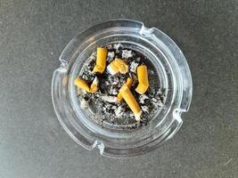 Top view of ashtray full of cigarette butts. photo