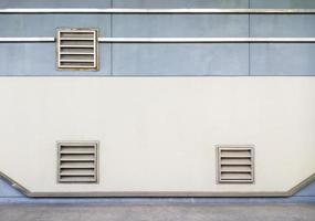 Metal grille of the ventilation system on the concrete wall. photo