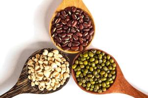 Legumes in a wooden spoon placed on a white background photo