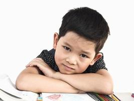 un niño asiático se está preparando felizmente para leer un libro, aislado en blanco foto