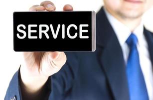 SERVICE, word on mobile phone screen in blurred young businessman hand over white background, business concept photo
