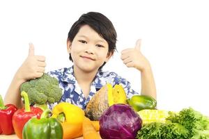 Asian healthy boy showing happy expression with variety fresh colorful vegetable over white background photo