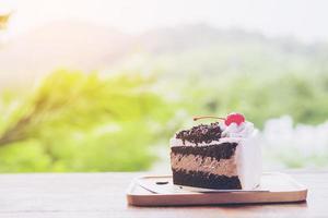 pastel de chocolate con fondo de naturaleza de montaña suave y enfocado foto