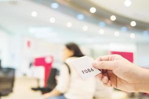 Man is holding queue card while waiting in the modern reception area photo