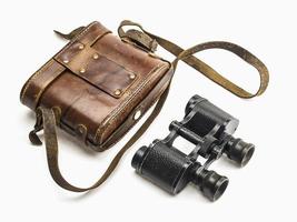 Old antique binoculars and its brown leather bag cover isolated over white background photo