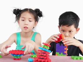 los niños asiáticos están jugando un juego creativo de bloques de plástico para practicar sus habilidades físicas y mentales foto