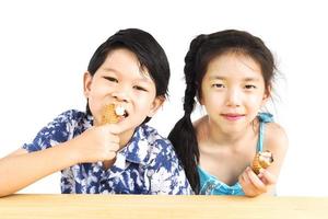 los niños asiáticos están comiendo helado foto