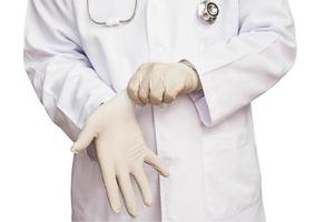 médico varón está poniendo guante listo para examinar a su paciente aislado sobre blanco. la foto incluye el camino de recortes.