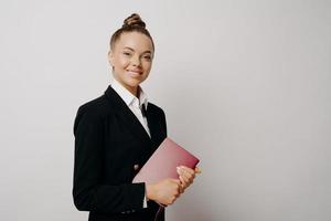 Female business woman with notebook smiling gladfully at camera photo