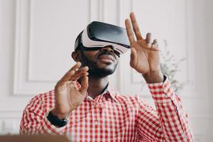 Black man in VR glasses experiencing 3D technology of augmented reality photo
