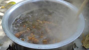 A close up shot of turmeric root being boiled in a big pot . Turmeric is a common spice that comes from the root of Curcuma longa. It contains a chemical called curcumin, which might reduce swelling. video