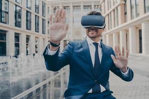 Excited office worker in formal suit checking information in virtual reality photo