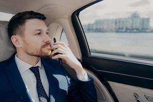 Serious company executive thinking of making serious decision while sitting in car photo