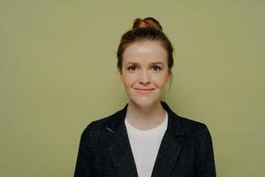 Studio portrait of smiling beautiful young woman with hair in bun photo