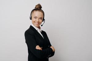 amable mujer de negocios con auriculares en traje oscuro lista para la conferencia web foto