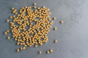 Top view of clean fresh garbanzo or chickpeas on grey background. Flat lay. Raw food for vegans. Close up. Ingredients full of protein photo