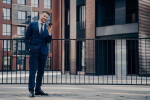 Male office worker chatting on smartphone while work break outdoors photo