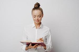 Female jouranlist taking important notes in notebook photo