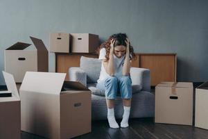 Tired european woman sitting among packed boxes. Hopeless young lady getting in trouble photo