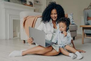 feliz madre africana y su hijo disfrutando de una videollamada con la familia foto