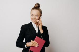 Business woman in suit having good talk on phone photo