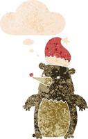 cartoon bear wearing christmas hat and thought bubble in retro textured style vector