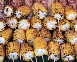 Roasted sweet corn with the wooden skewer. photo