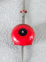 Fire alarm bell on the white concrete wall. photo