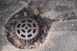 Closeup of old metal grille on the drainage pipe. photo