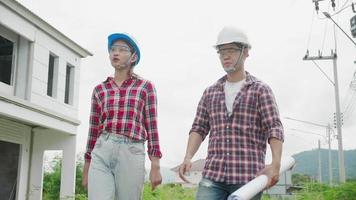 trabalhadores da construção civil com planta falando no canteiro de obras