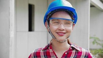 portrait d'une belle ingénieure souriante portant des lunettes de sécurité et un casque video