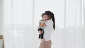 madre soltera asiática sosteniendo a una adorable niña para consolarlo después de despertarse. video