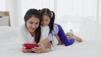 Mom teaching cute preschool daughter learning reading ebook on digital tablet video