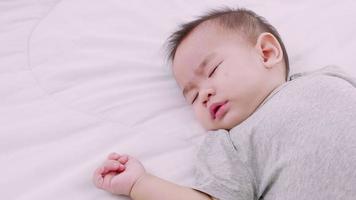 slapende schattige babymeisje op bed overdag. bescherming van kinderen. video